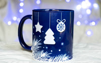 Mug magique de Noël : tout blanc et quand il reçoit une boisson chaude, il devient bleu avec des dessins de Noël blancs.