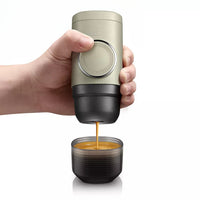 Cafetière Portable Ergonomique à Capsules, sur un fond blanc.