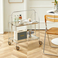 Meuble Machine à Café Pliante à Roulettes, sur un sol en parquet, avec des objets posés dessus, à côté d'une table et d'une chaise dans un salon.