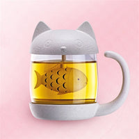Mug Infuseur en Forme de Chat avec son Filtre Poisson, sur un fond rose.