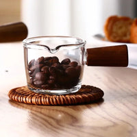 Verre à Café Transparent avec Poignée en Bois, avec des graines de café à l'intérieur.