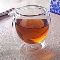 Verre Double Paroi Transparent Moderne avec du thé à l'intérieur et posé sur un tissu